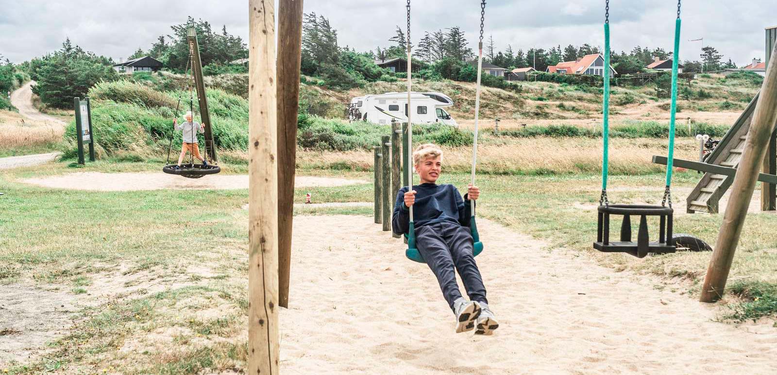 Dreng gynger ved autocamper