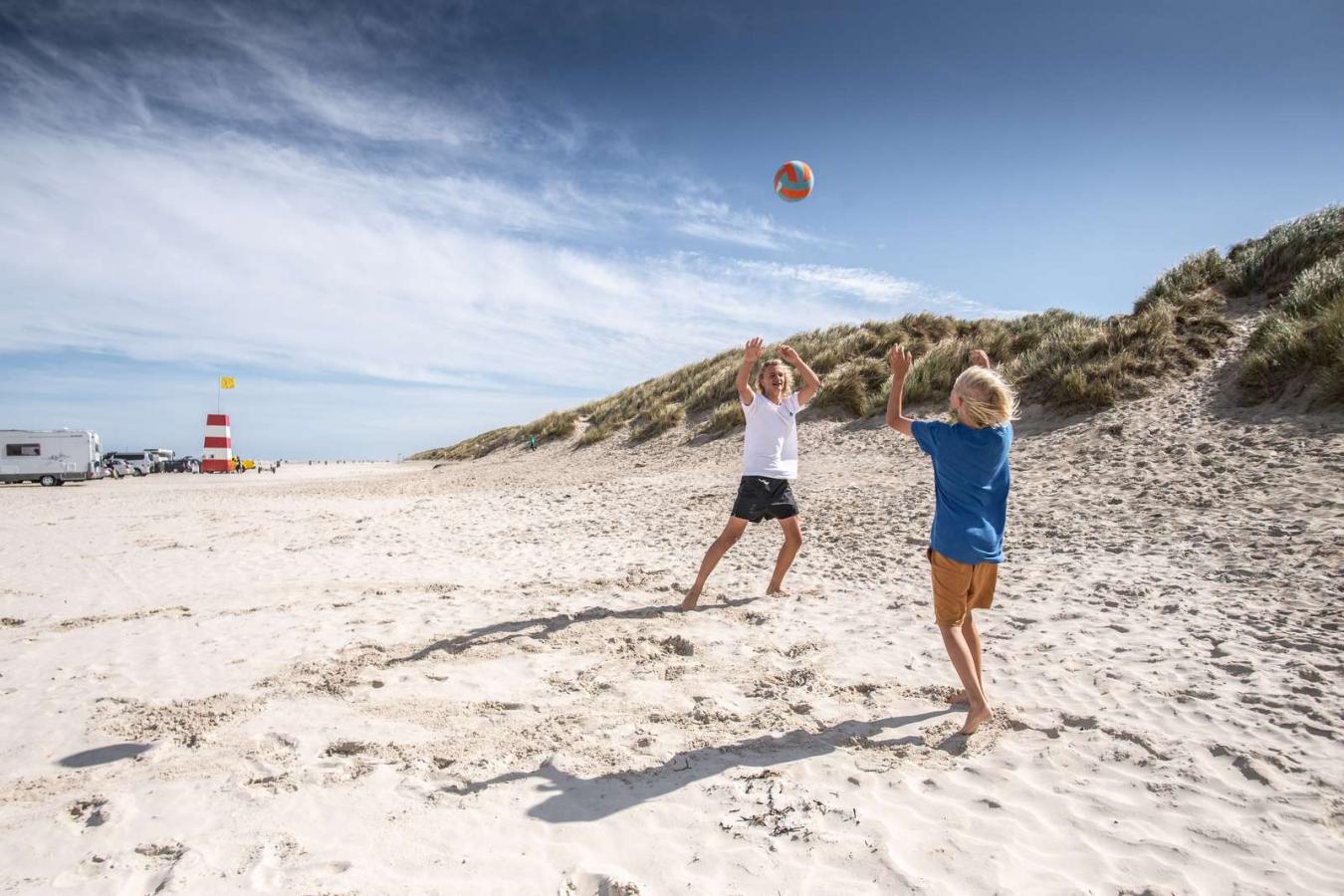 Børn spiller bold ved stranden