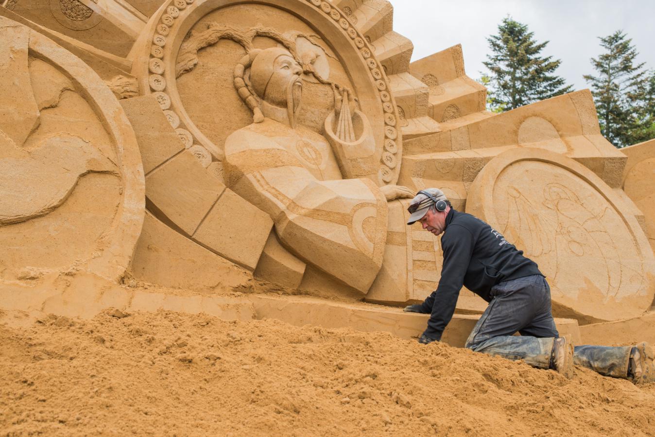 Skulptør arbejder på sandskulptur